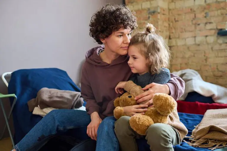 Child with teddy bear and woman on bed