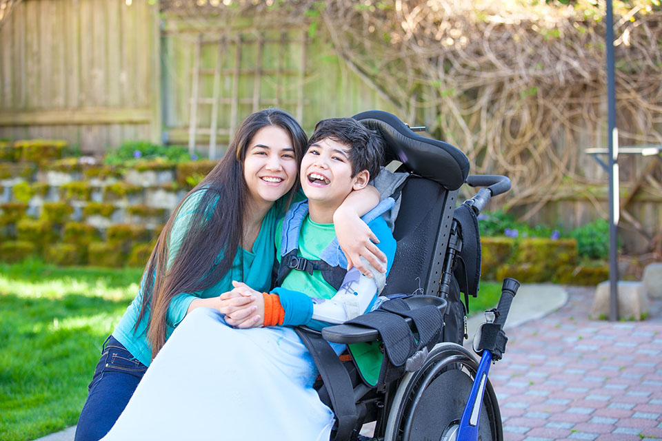 Child in a wheelchair with woman
