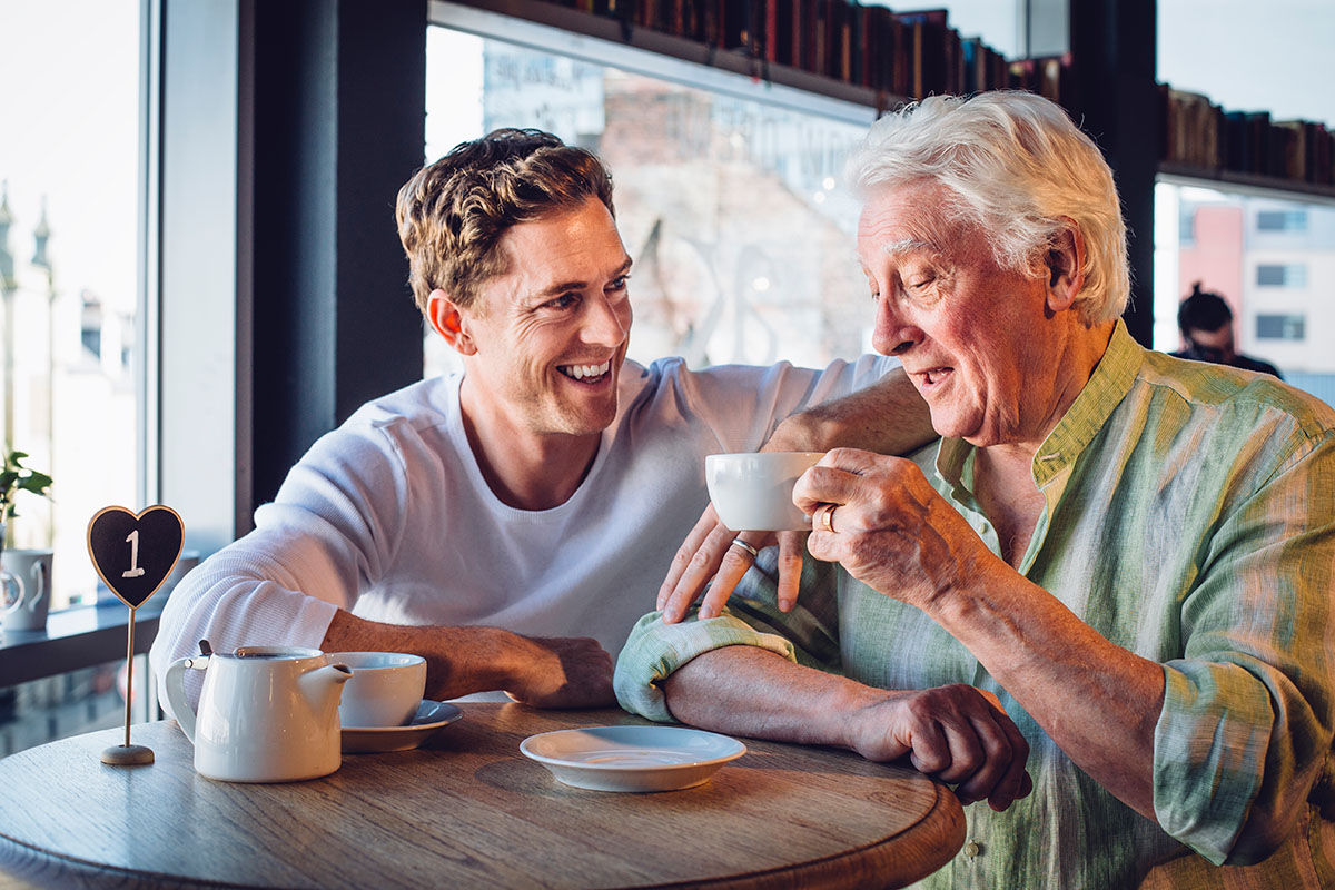 elderly man having a coffee with another man