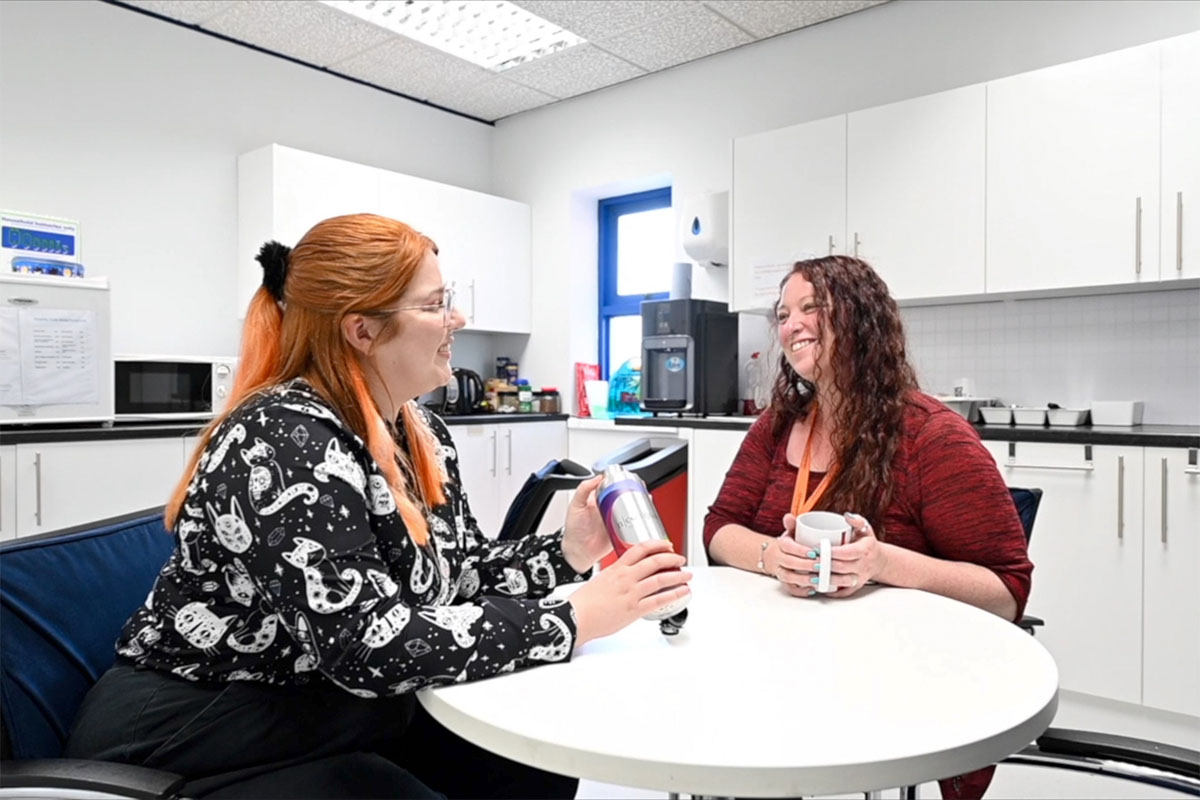 Two women at a desk smiling